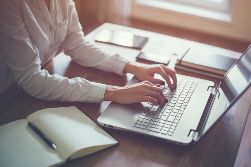 Woman working in home office hand on keyboard close up.